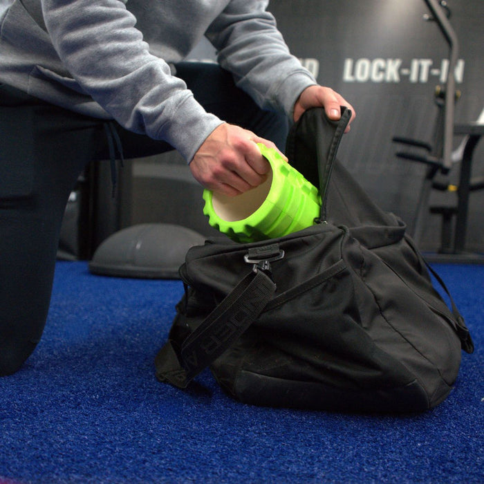 Gronk Fitness green foam roller being packed in a gym bag