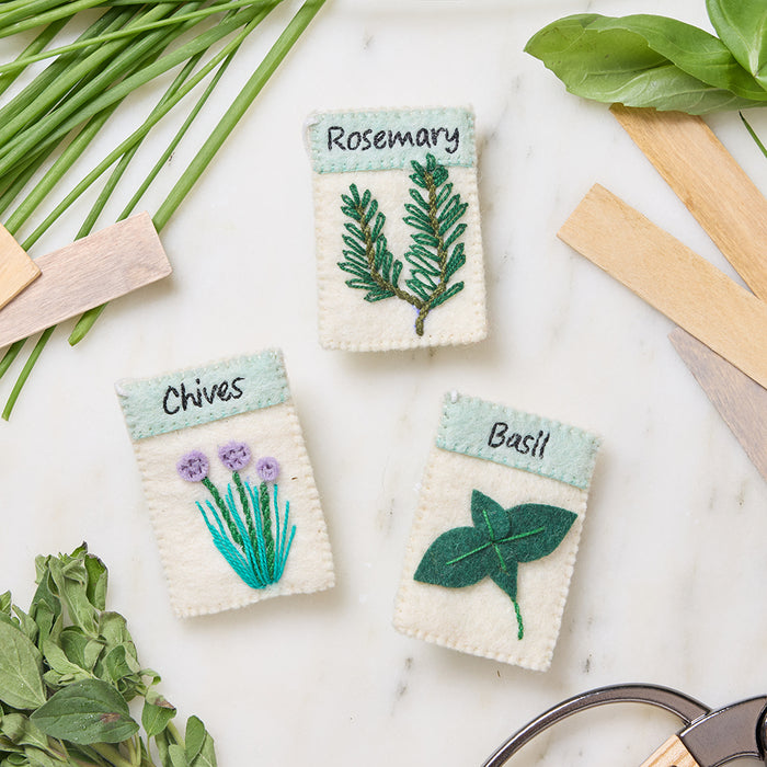 Felt seed packet ornaments featuring basil, chives, and rosemary with garden-inspired details