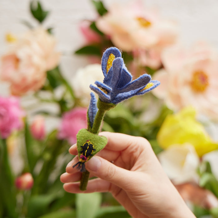 Close-up of hand-felted iris petals with detailed stitching and perched firefly