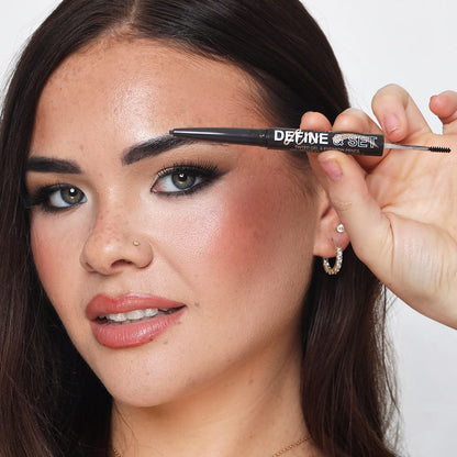 Dual-ended Technic brow pencil and gel tool held above defined brow