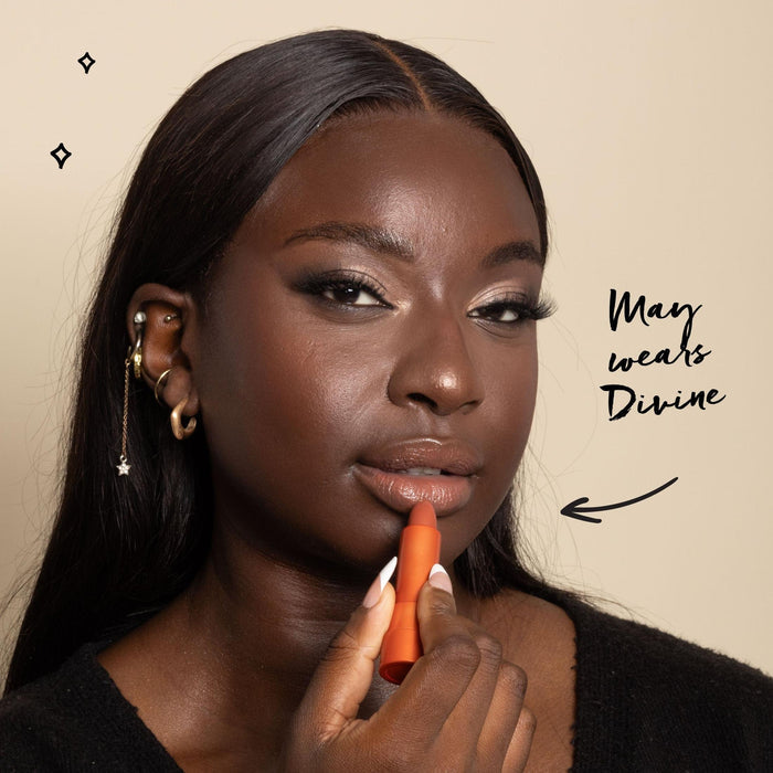 Model applying one of the lipsticks and text saying she uses the shade Divine
