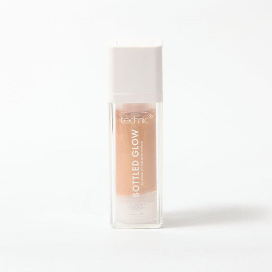 Clear bottle of Technic Bottled Glow peachy-gold shimmer oil on white background