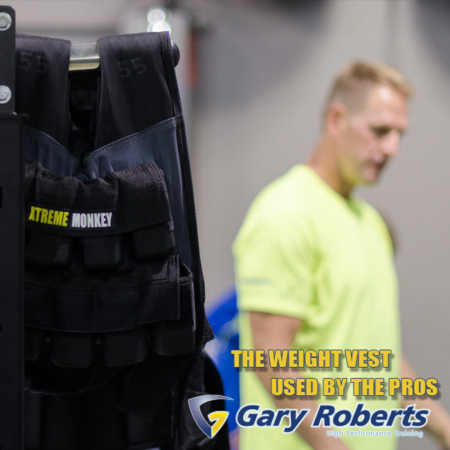 XM Fitness weighted vest hanging on gym equipment