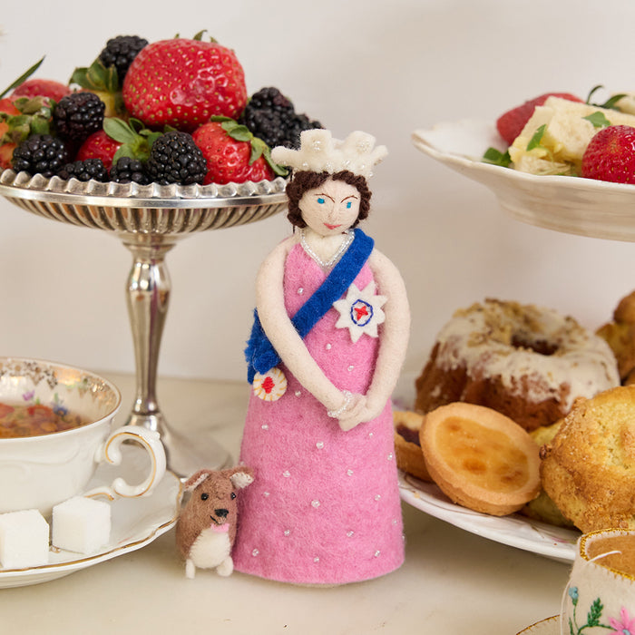 Young Queen Elizabeth II felt ornament in gala attire with a loyal corgi at her side. Handmade wool Christmas ornament honoring British royalty. Fair trade and ready to hang.