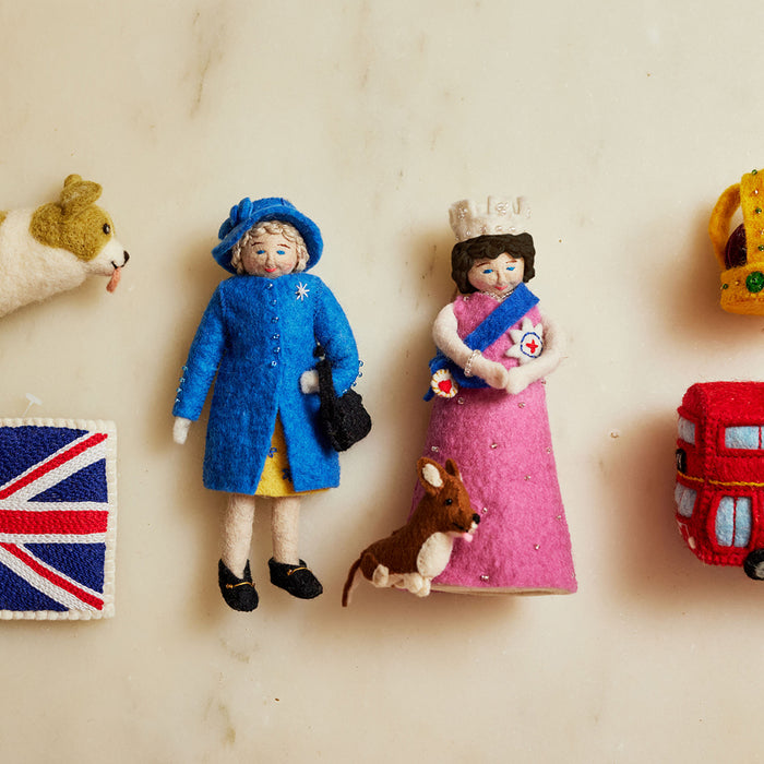 Young (and old) Queen Elizabeth II felt ornament in gala attire with a loyal corgi at her side. Handmade wool Christmas ornament honoring British royalty. Fair trade and ready to hang.